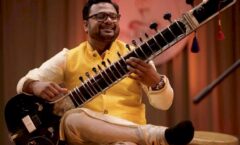 Musician tuning sitar in music studio