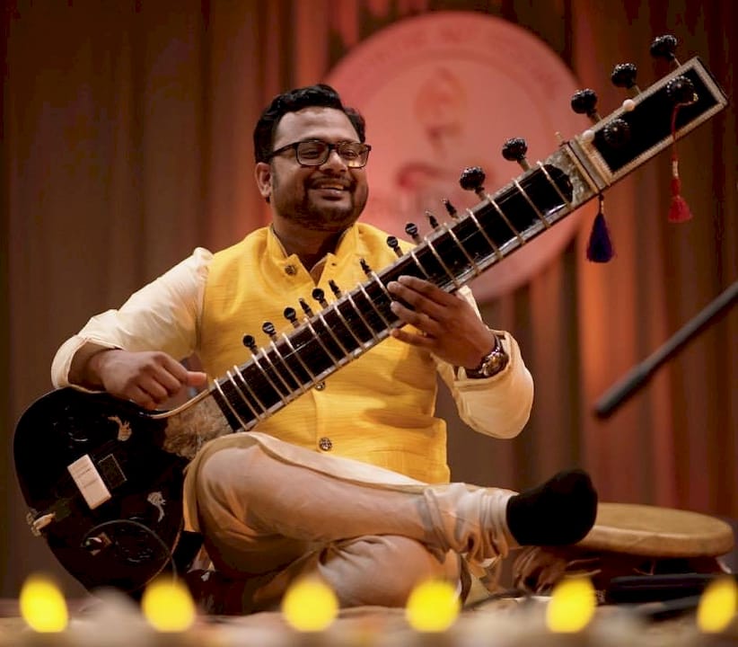 Musician tuning sitar in music studio