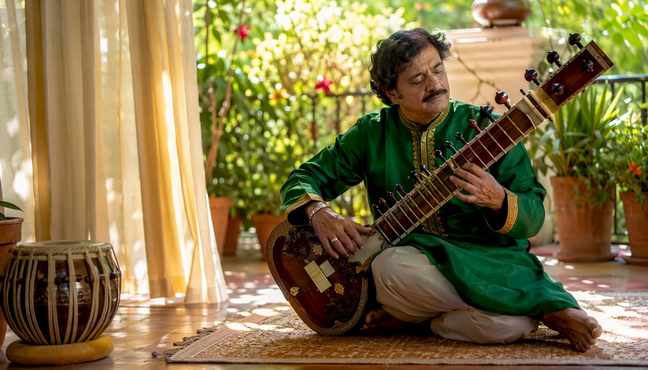 Indian sitar player performing raga music on stage
