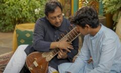 Sitar teacher demonstrating plucking to student