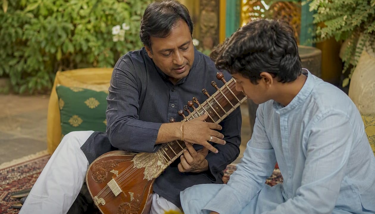 Rajib Karmakar sitarrajib Sitar Lesson Cost in India: Prices and What to Expect 1 Sitar teacher demonstrating plucking to student