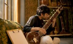 Composer playing sitar during spotting session