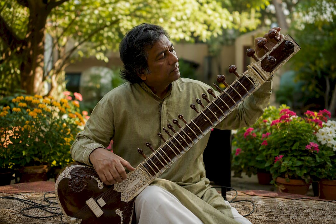 Sitarist tuning sitar for TV music pitch