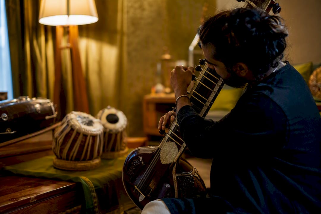 Musician tuning sitar in film scoring studio