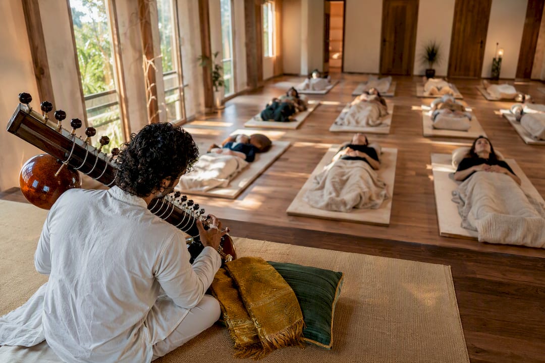 Sitarist performing for reclining sound bath listeners